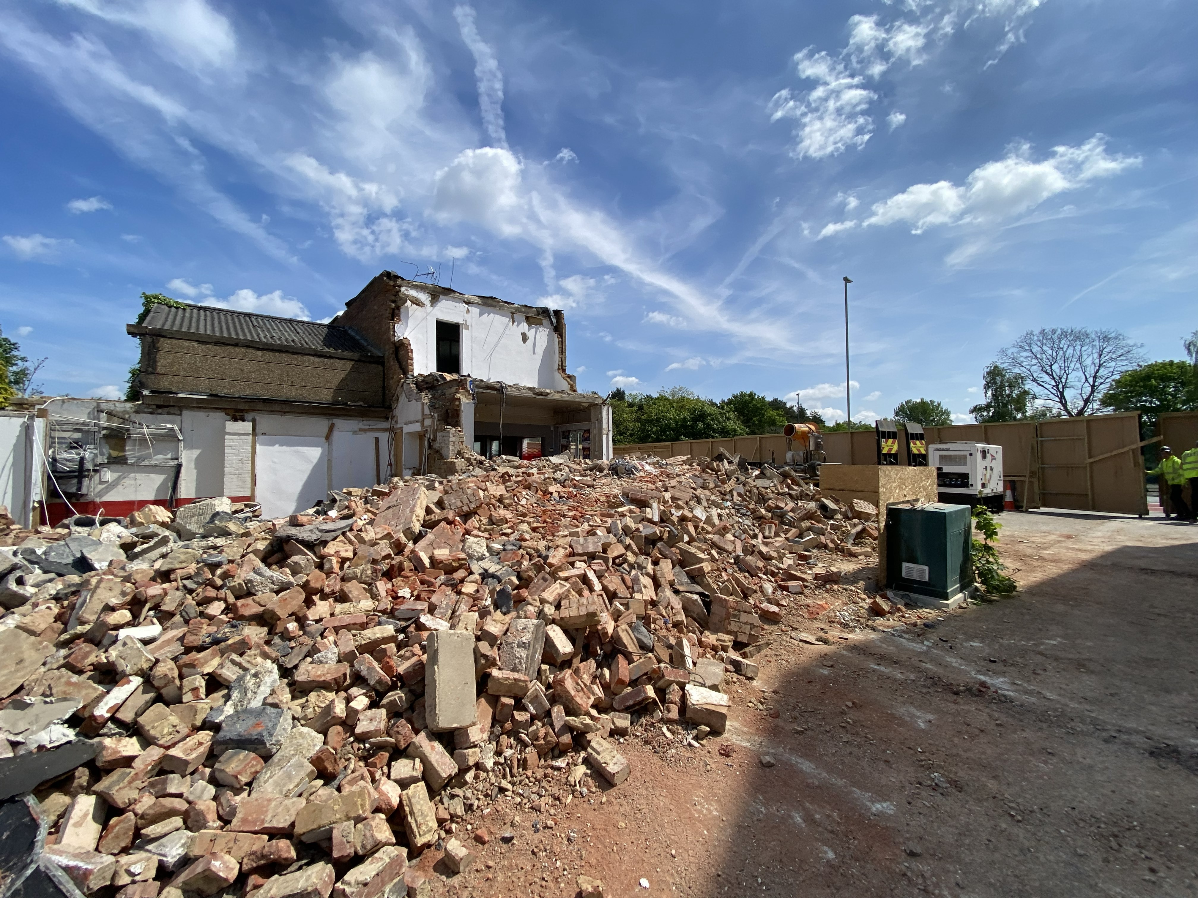 Demolition front site rubble piles remaining structure
