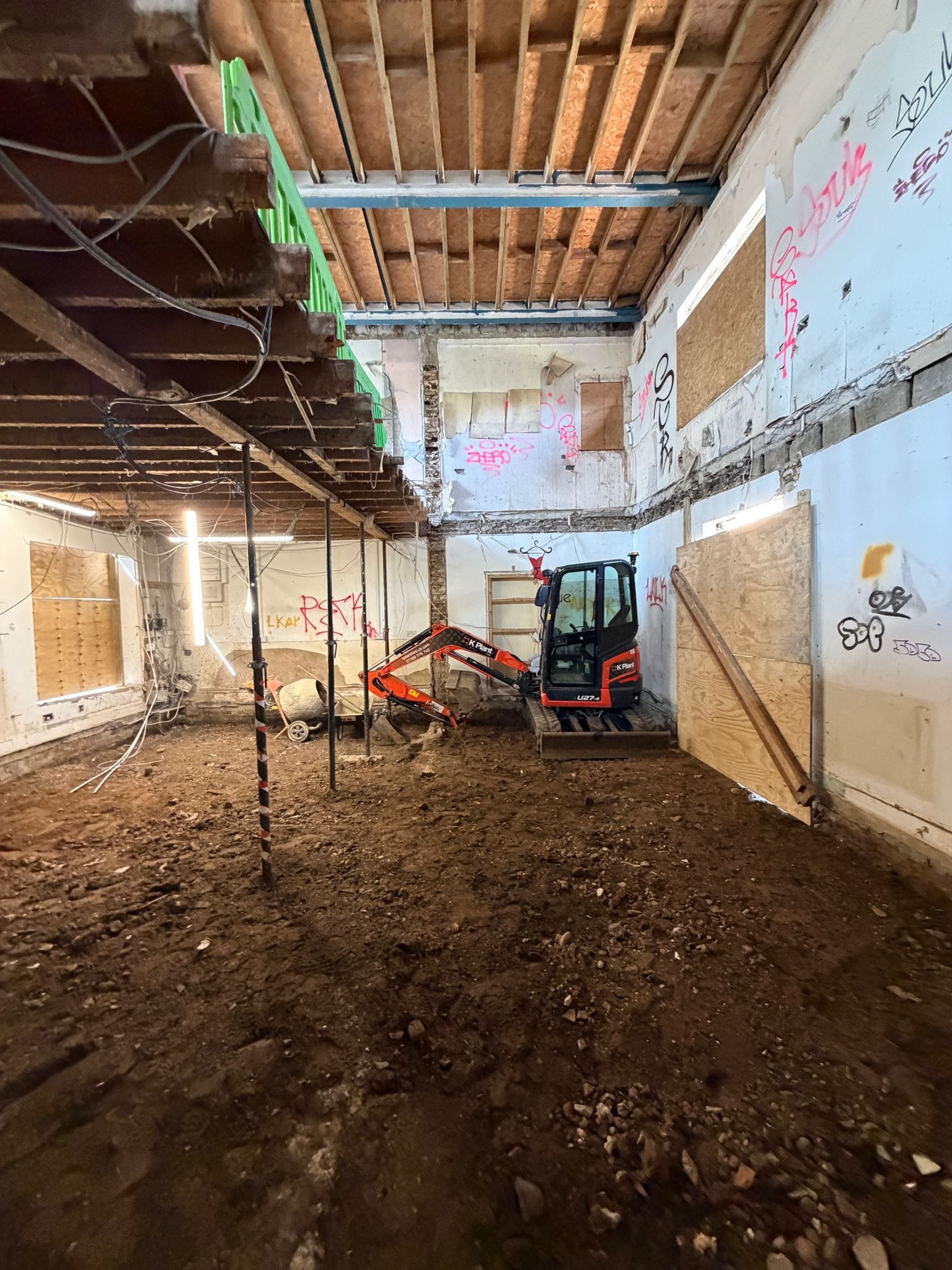 Underpinning mini excavator within structure acrow props